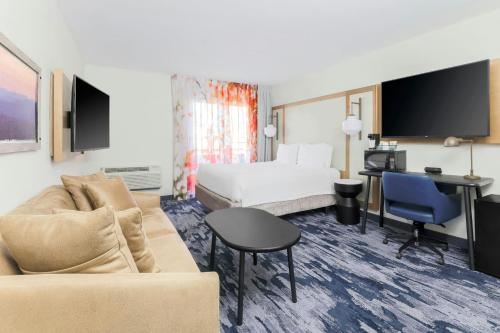a hotel room with a couch and a bed and a desk at Fairfield Inn and Suites by Marriott San Jose Airport in San Jose