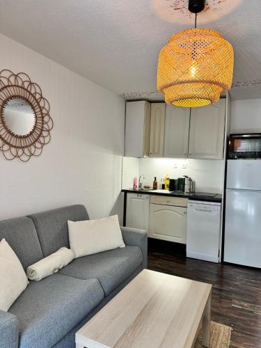 un salon avec un canapé et une cuisine dans l'établissement Studio Terrasse à Sainte-Maxime Classé Meublé de Tourisme, à Sainte-Maxime