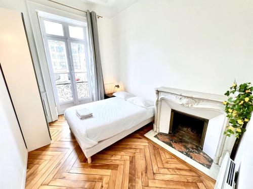 une chambre avec un lit et une cheminée dans l'établissement T3 rénové vue sur le centre de Rennes, à Rennes