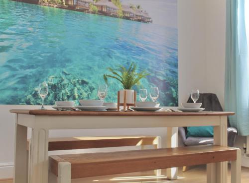 Bamber BridgeにあるYour lovely 3-bed home-from-home in Bamber Bridgeの海の絵が飾られたダイニングテーブル