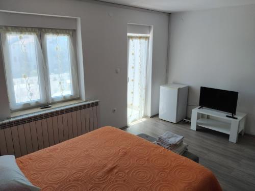 Room Benjamin في بوريتش: غرفة نوم مع سرير وتلفزيون بشاشة مسطحة