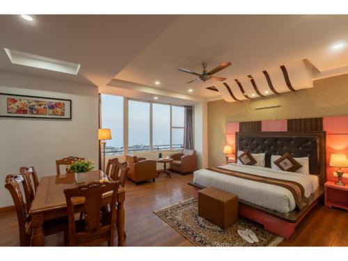 a bedroom with a bed and a dining room with a table at Hotel Shiva Sanctuary by DLS Hotels, McLeod Ganj in Dharamshala