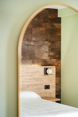 a bedroom with a bed and a wooden wall at Tirreno CODE ROOMS in Tarquinia