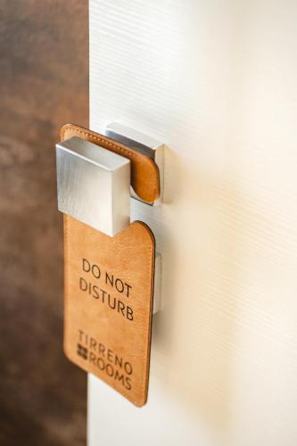 a do not disturb sign attached to a door at Tirreno CODE ROOMS in Tarquinia