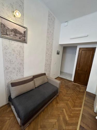 a couch in a living room with a wooden floor at Velez Ház in Budapest