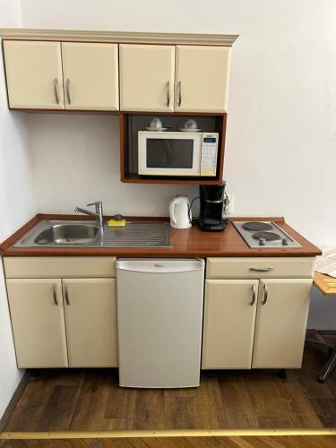 a small kitchen with a sink and a microwave at Velez Ház in Budapest