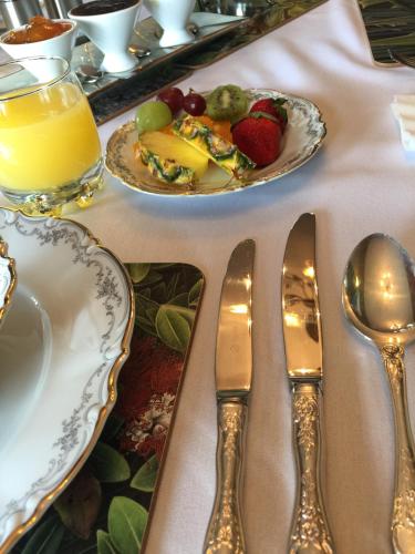 a table with two plates of food and silver spoons at The Flying Trout Boutique Lodge in Taupo