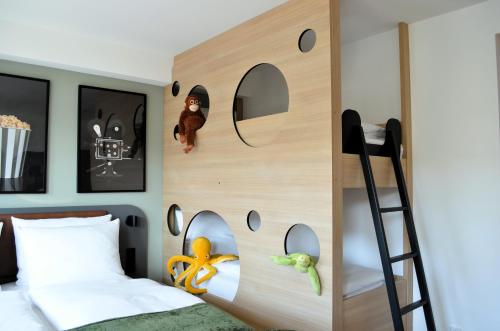 a bedroom with a bunk bed with a ladder at Cinema City Hotel Europaplatz Karlsruhe - Brand New Boutique Hotel 2025 - in Karlsruhe