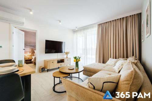 a living room with a couch and a table at Apartament TUKAN w SARBINOVE z garażem - 365PAM in Sarbinowo