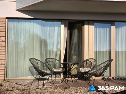 a group of chairs and a table on a patio at Apartament TUKAN w SARBINOVE z garażem - 365PAM in Sarbinowo
