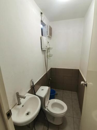 a small bathroom with a toilet and a sink at Ken's Inn in Coron
