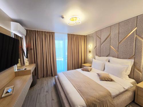 a hotel room with a large bed and a flat screen tv at MONARC Boutique ApartHotel - SELF CHECK-IN in Iaşi