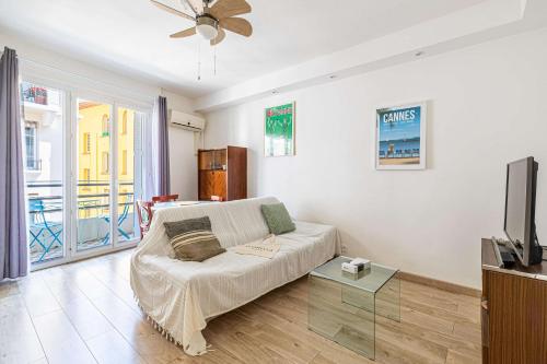 un salon avec un canapé et une télévision dans l'établissement L'ANGLE DOUX avec balcon idéal pour couples ou en solo, à Cannes