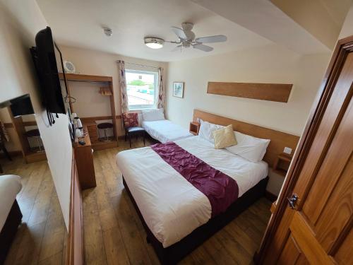 a bedroom with two beds and a flat screen tv at Villager Hotel, Ingoldmells in Ingoldmells