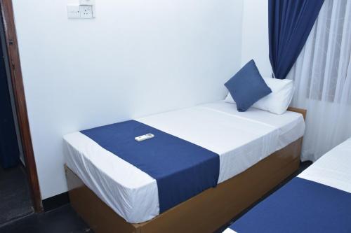 a bedroom with a bed with a blue and white sheets at Coastal Heaven Villa in Trincomalee