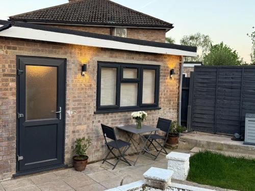 a patio with a table and chairs in front of a house at Newly Renovated Guesthouse with Free Parking in Reading