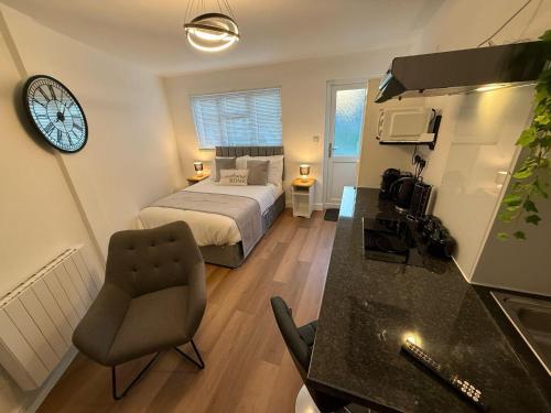 a bedroom with a bed and a clock on the wall at Newly Renovated Guesthouse with Free Parking in Reading