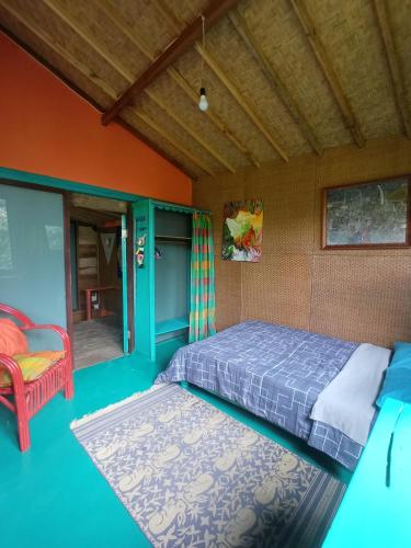 a bedroom with a bed and a red chair at Ubud Jungle River in Ubud