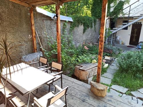 a wooden deck with a table and chairs and a garden at Номер в доме у моря с бассейном in Odesa