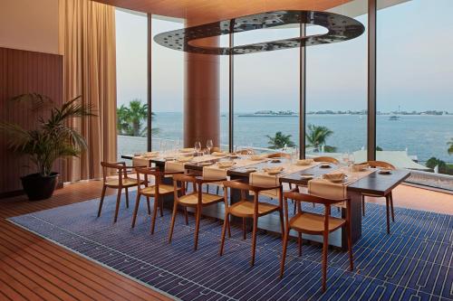 a dining room with a long table and chairs at Bvlgari Resort Dubai in Dubai