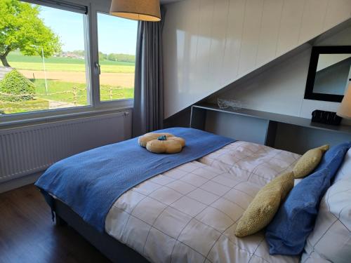 una camera da letto con un letto grande con una grande finestra di Boave ut Wirkes a Klimmen