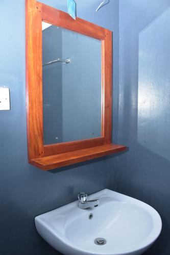 a bathroom with a mirror and a white sink at Coastal Heaven Villa in Trincomalee