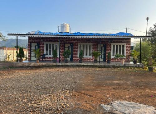 a brick house with a blue roof at Natural Lake Pawna in Lonavala