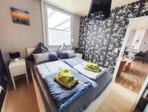 a bedroom with a bed with two yellow bags on it at Das Häuschen in Taddigshörn in Bensersiel