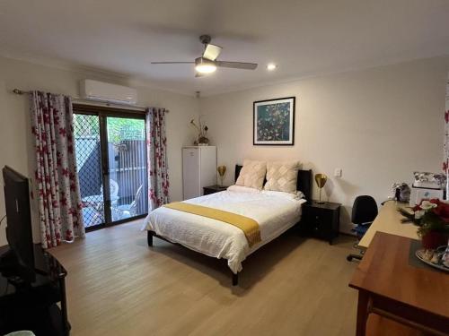 a bedroom with a bed and a desk and a window at Garden Retreat House Sunnybank Hills - Super quite and Peace in Brisbane