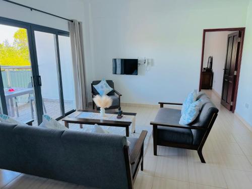 a living room with a couch and a table at Bijoutier Apartments in Grand'Anse Praslin