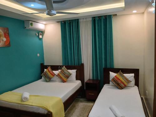 two beds in a room with green walls at Nyali best pavil in Mombasa