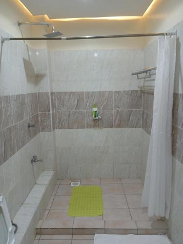 a bathroom with a shower with a green rug at Nyali best pavil in Mombasa
