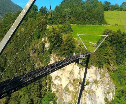 a suspension bridge over a mountain with a road at Apartment Oberleins I in Arzl im Pitztal