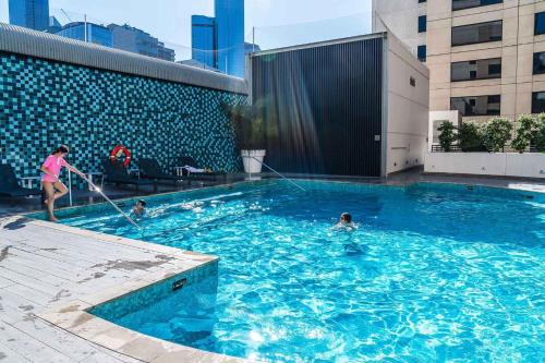 a woman in a swimming pool with at Crowne Plaza Melbourne by IHG in Melbourne