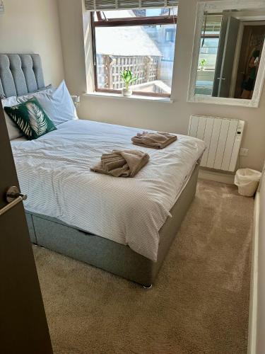 a bedroom with a large bed with towels on it at Seaside Escape - Deganwy Beach Cottage - Sea Views & Golf Course Views in Deganwy