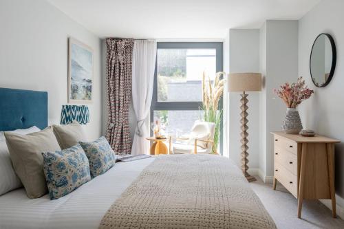 a bedroom with a large bed and a window at Sands Edge in Salcombe