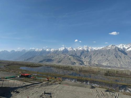 a view of a mountain range with a body of water at The Crescent Resort in Skardu