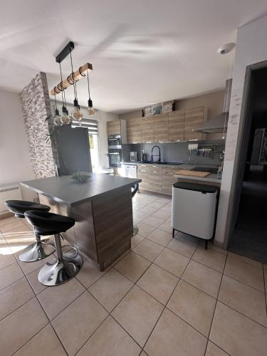 a kitchen with a large island in the middle at Maison avec piscine chauffée, plages du débarquement in Crouay