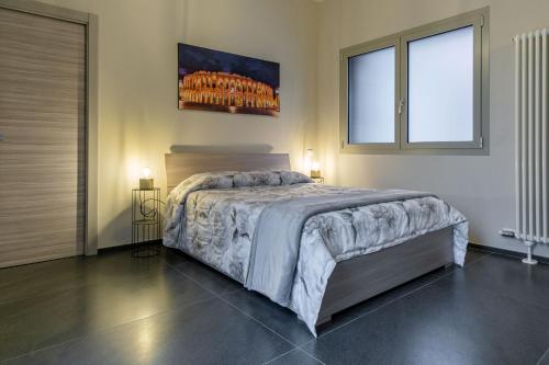 a bedroom with a large bed with two windows at Residenza Grazioli 2 in Verona