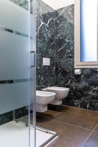 a bathroom with two toilets and a glass shower at Residenza Grazioli 2 in Verona