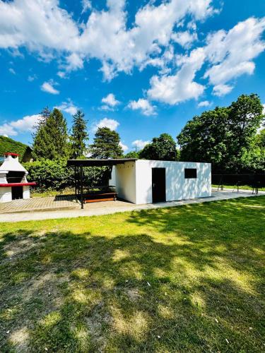 a white building in a park with a grass field at Spacious 6BR Shared Villa with Garden near Danube For 16 Guests in Vienna