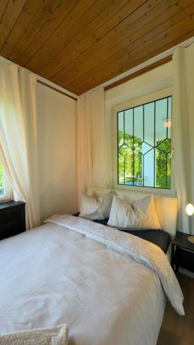 a bedroom with a large white bed with a window at Spacious 6BR Shared Villa with Garden near Danube For 16 Guests in Vienna