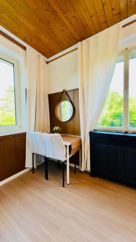 a dining room with a table and chairs and windows at Spacious 6BR Shared Villa with Garden near Danube For 16 Guests in Vienna