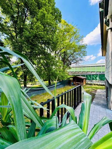 a green park bench with trees and a bridge in the background at Spacious 6BR Shared Villa with Garden near Danube For 16 Guests in Vienna