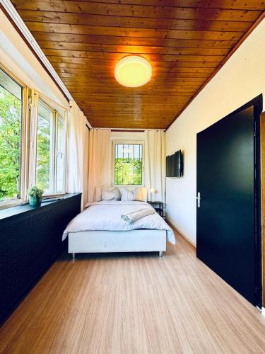 a bedroom with a bed and a wooden ceiling at Spacious 6BR Shared Villa with Garden near Danube For 16 Guests in Vienna