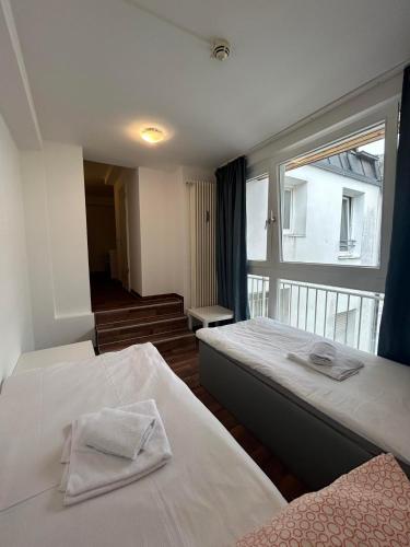 a hotel room with two beds and a window at 2-Rent Group Hostel Apartments SEN14 in Munich