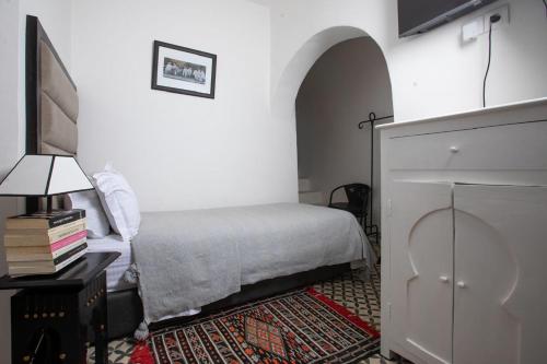 a bedroom with a bed and a tv on a table at Dar Lalzohra in Rabat