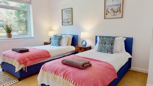 a bedroom with two beds and a window at Rosehill Walk Peaceful Ground Floor Home in Central Tunbridge Wells in Royal Tunbridge Wells