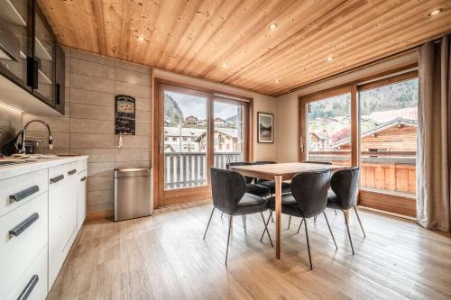 une cuisine avec une table et des chaises dans une pièce dans l'établissement Janin 3 Charmant appartement rénové avec 2 chambres et espace cabine, à Morzine