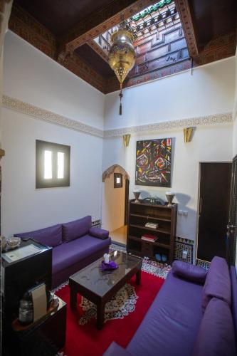 a living room with purple couches and a piano at Dar Lalzohra in Rabat